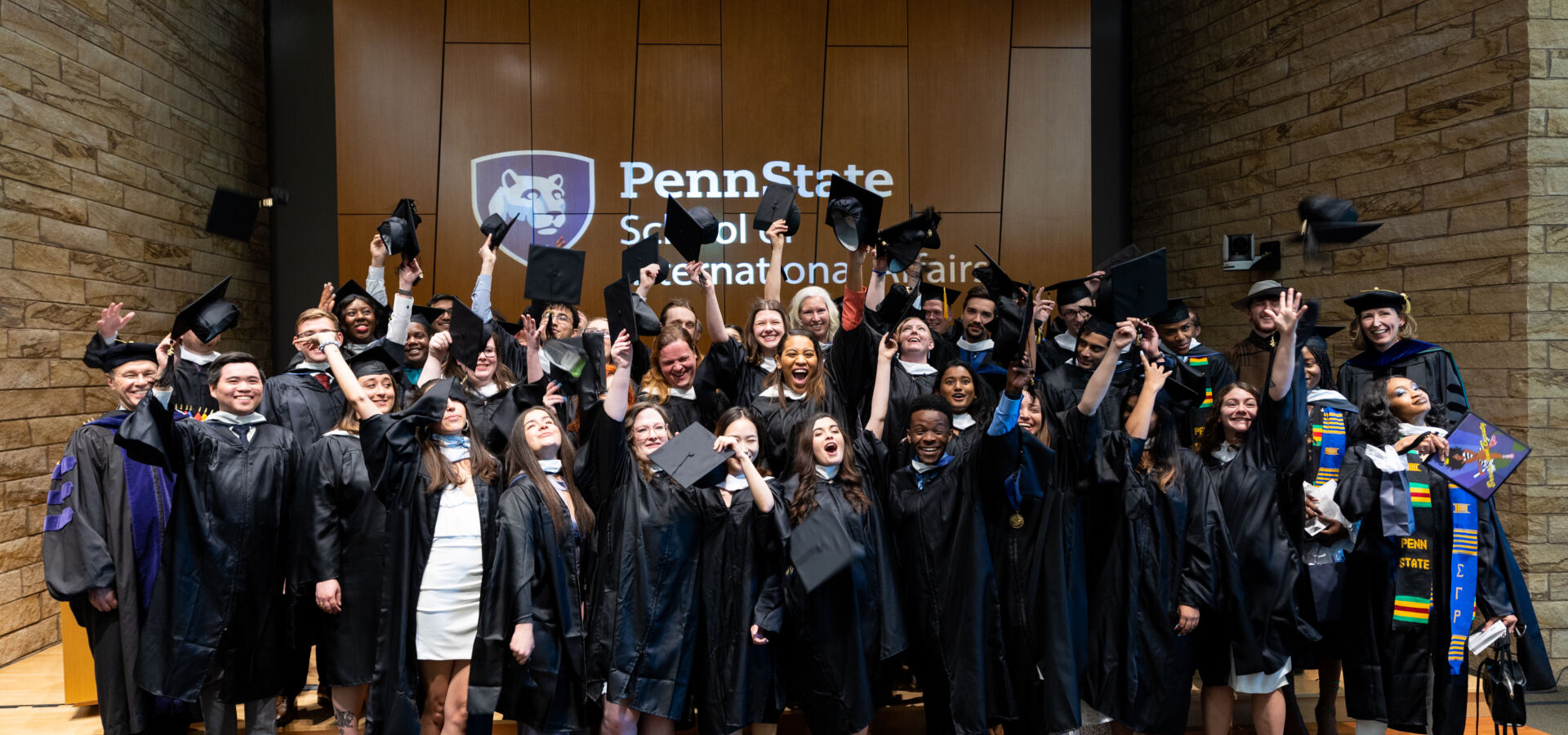 Recognition ceremony grads with hats in the air