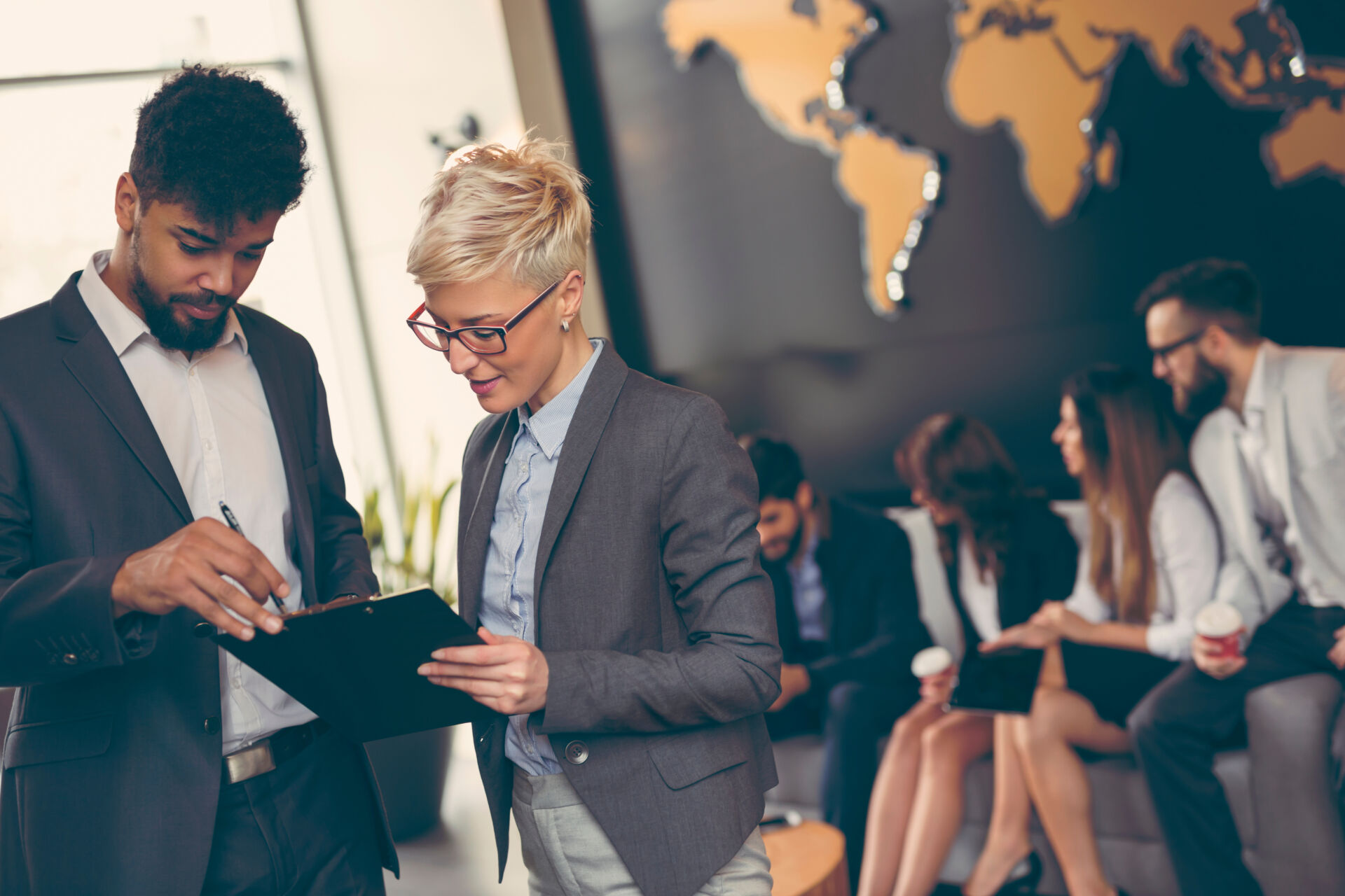 Business people working together in front of a world map